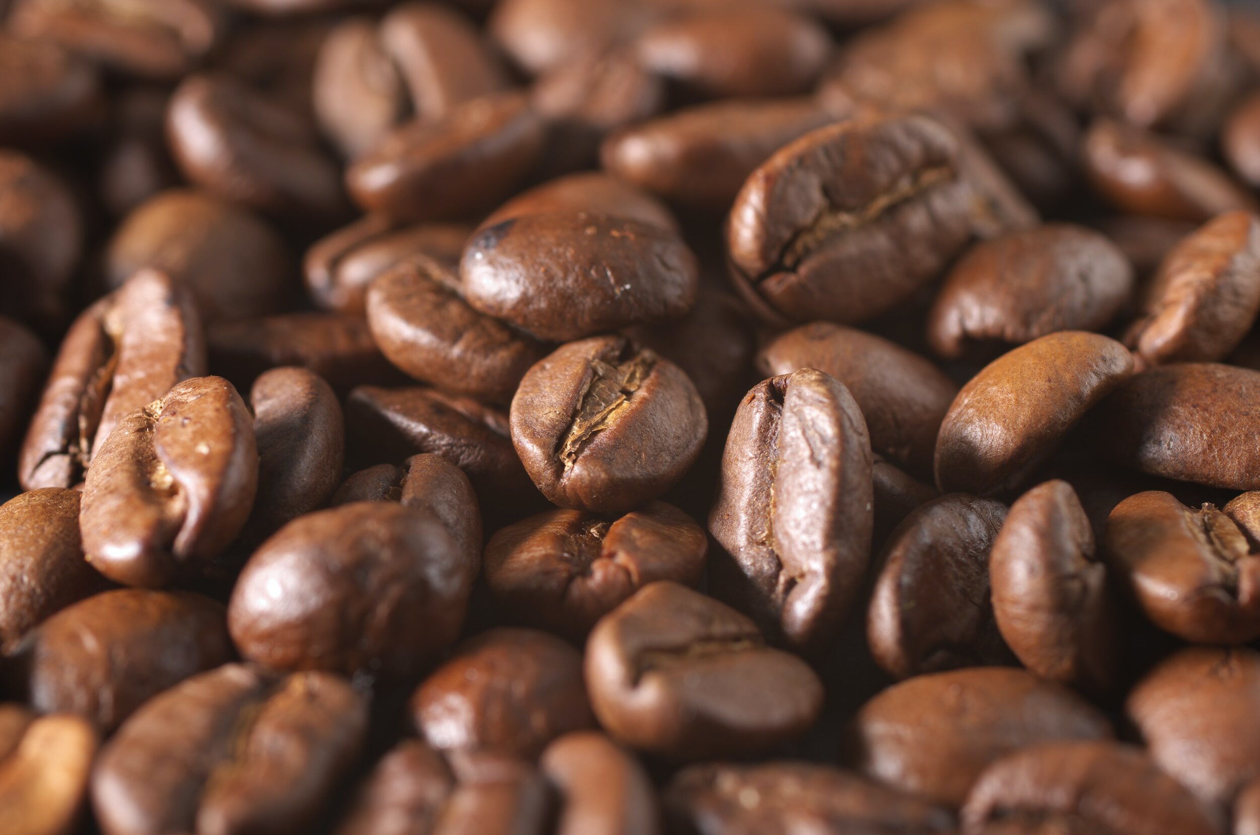Close-up of roasted coffee beans showcasing their rich, dark brown color and unique textures, ideal for coffee enthusiasts and brewing enthusiasts.